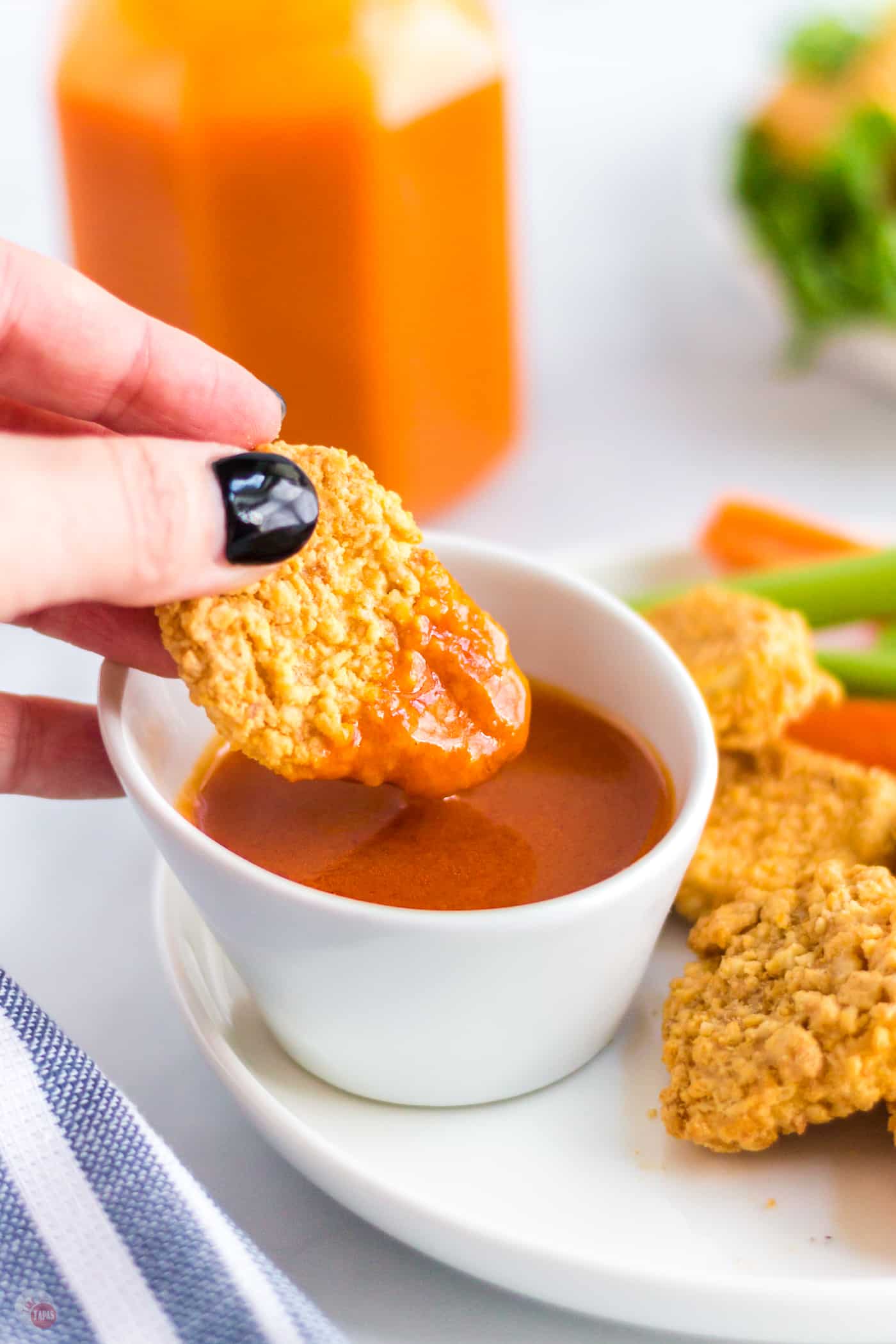 chicken nugget dipping in wing sauce