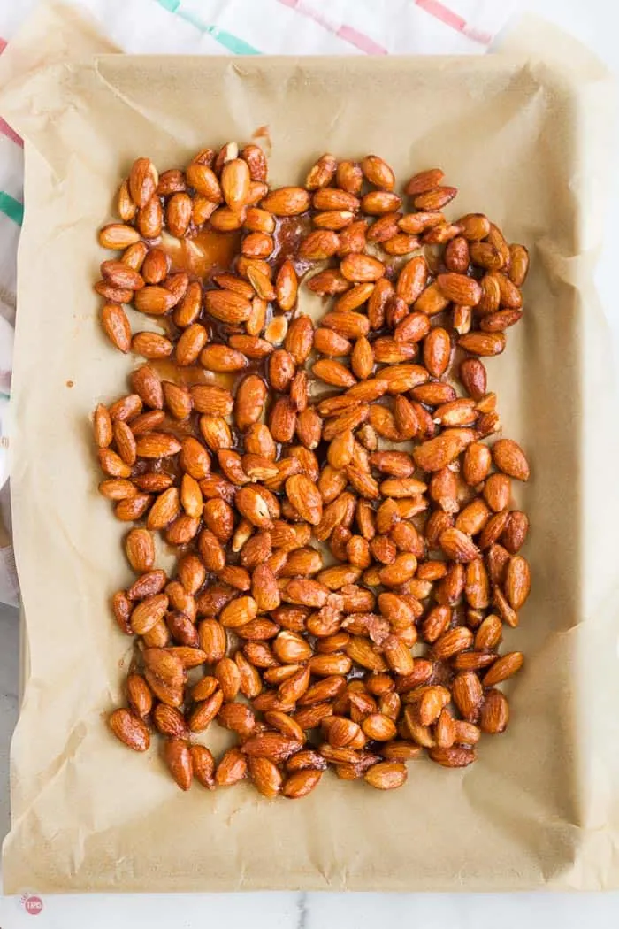 glazed almonds on a baking sheet with paper