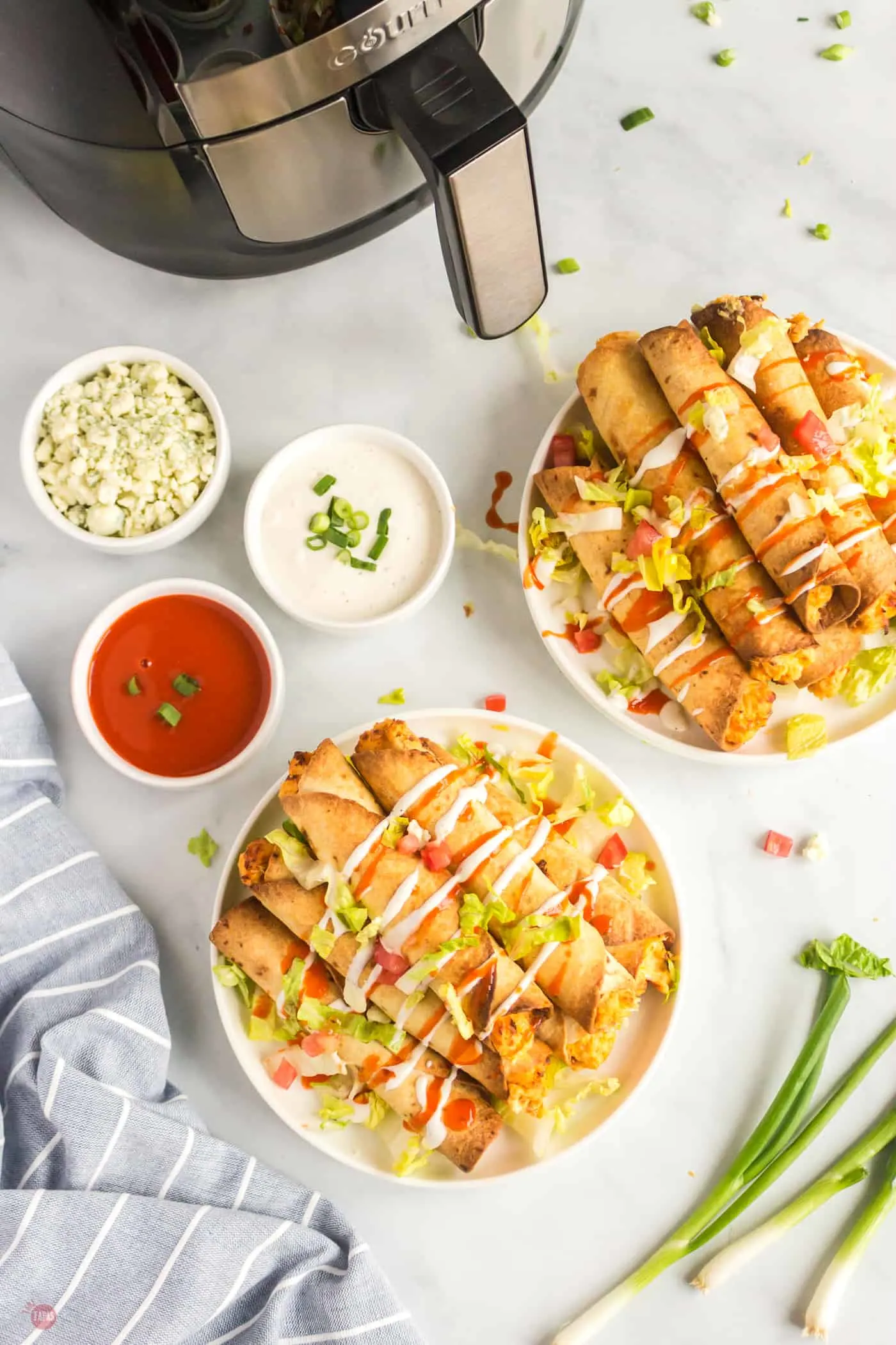 overhead picture of two plates of taquitos