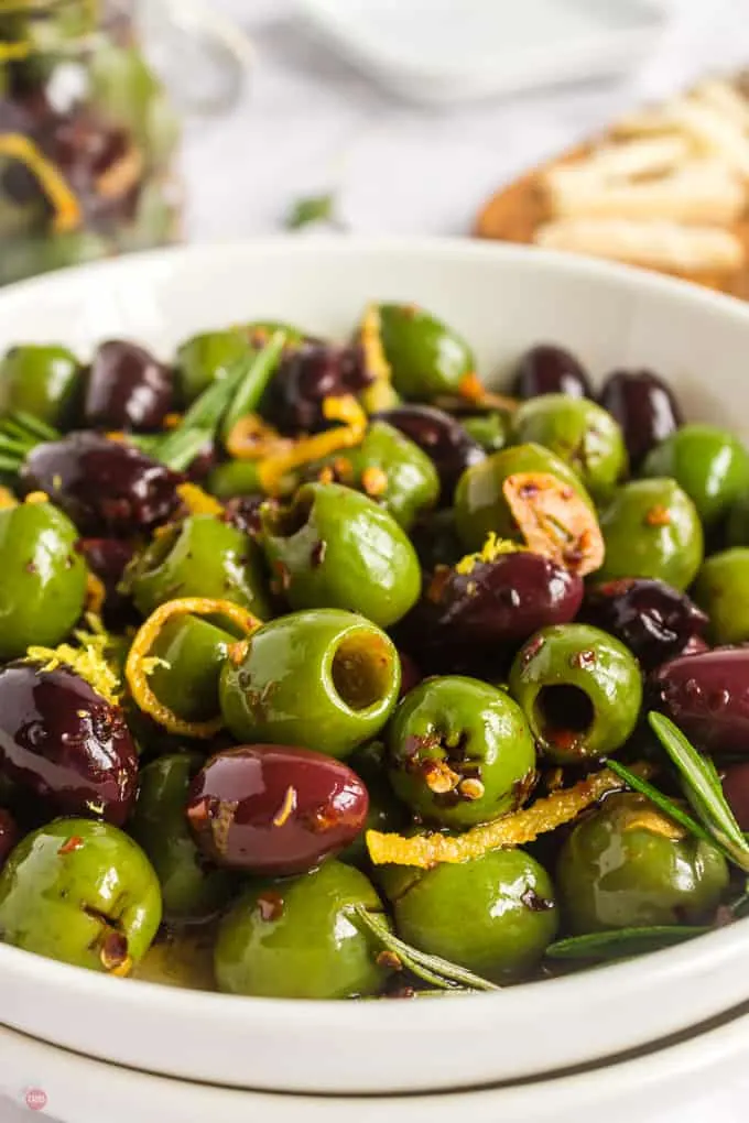 close up of olives in a white bowl