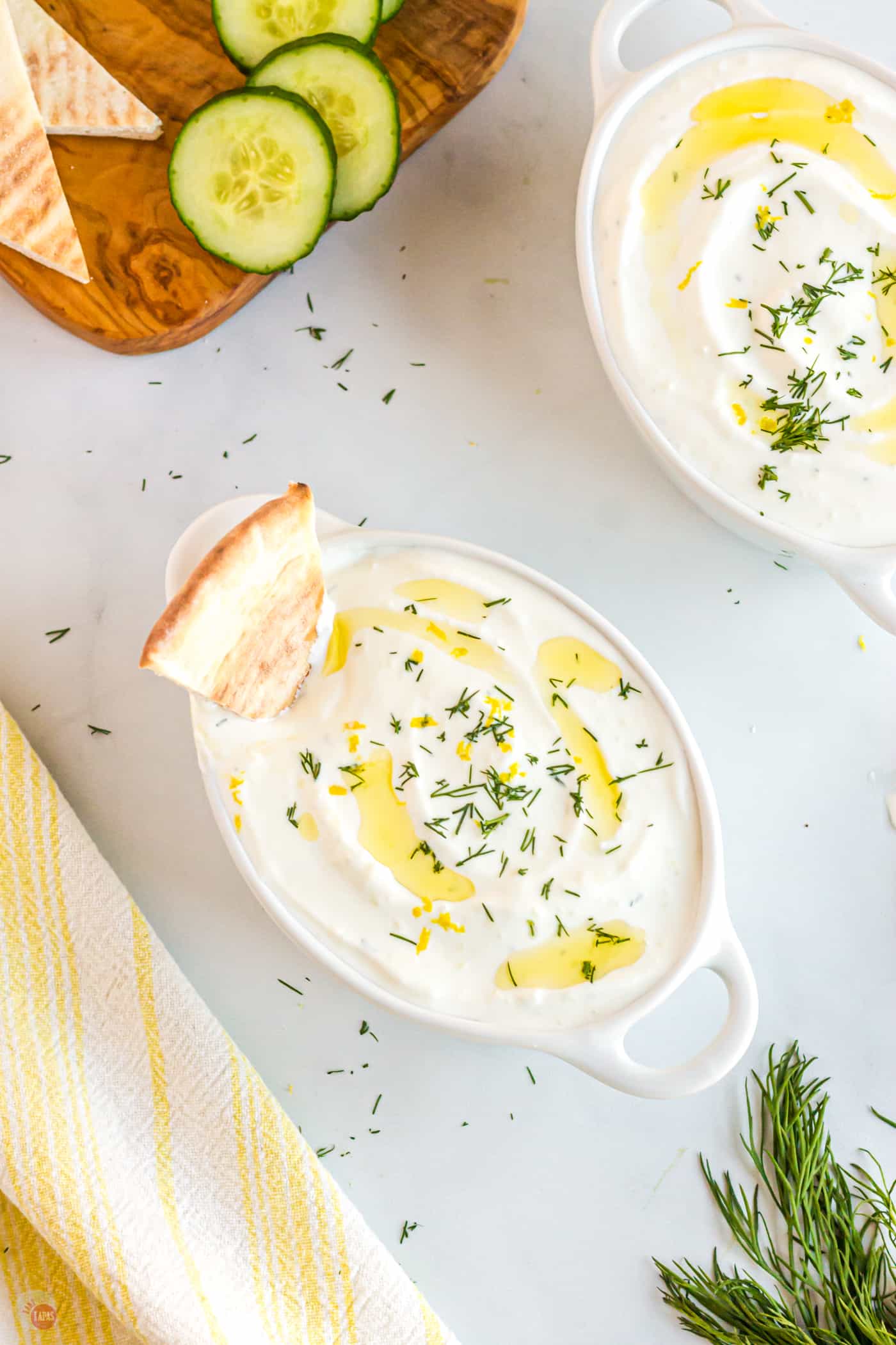 two bowls of tzatziki sauce wth pita