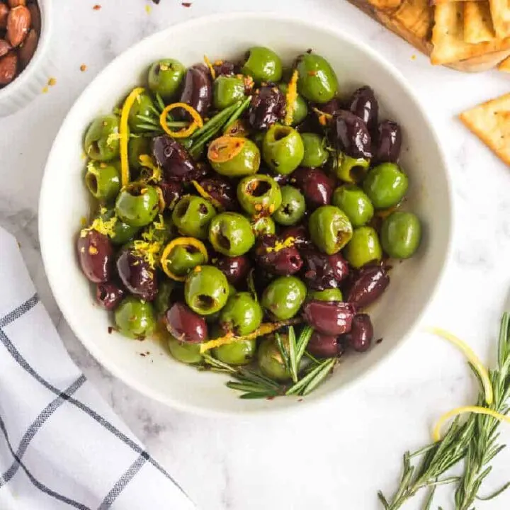 white bowl of olives and rosemary