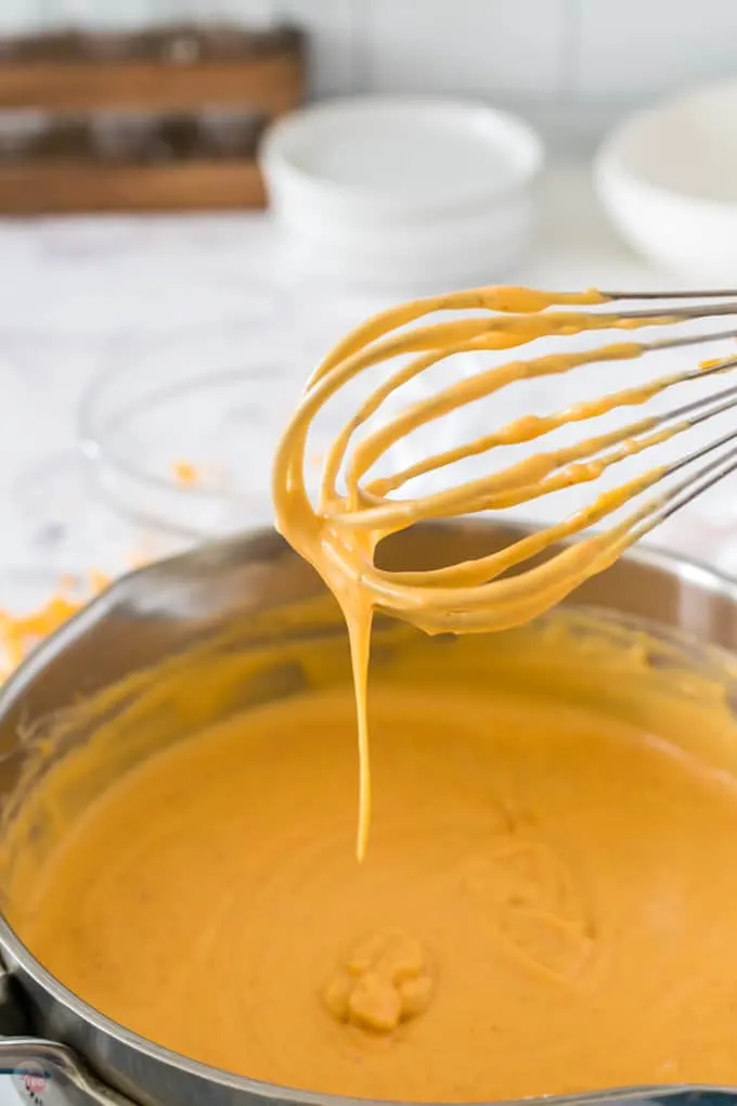 whisk with cheese sauce