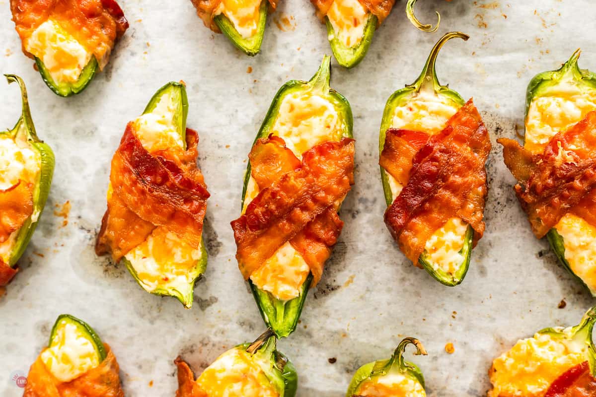 three jalapeno poppers on a baking sheet