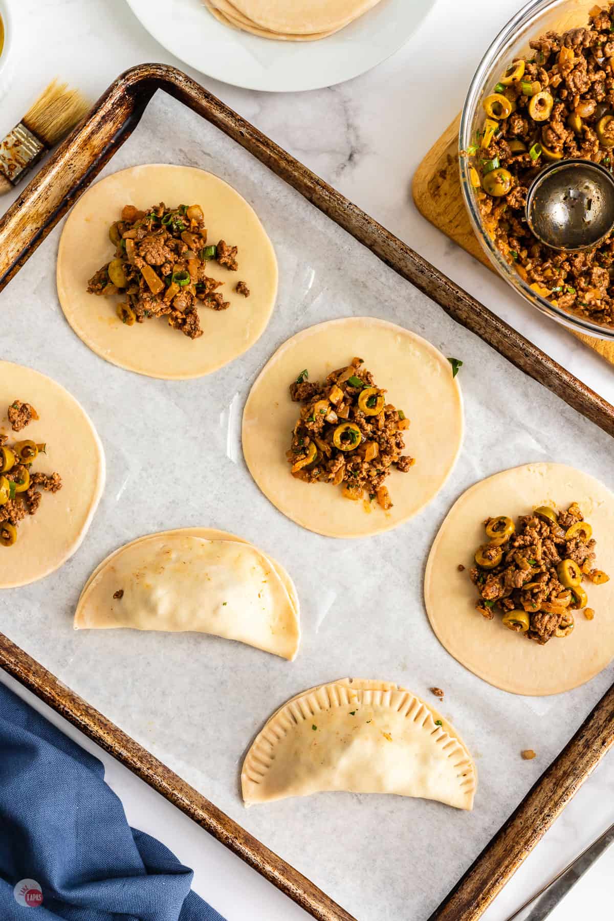 uncooked empanadas on baking sheet