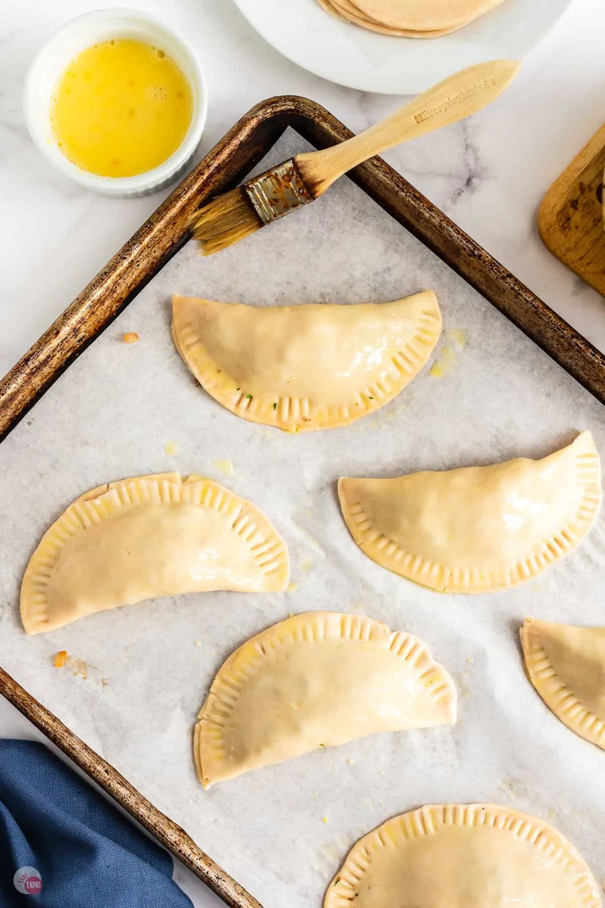 uncooked empanadas on baking sheet