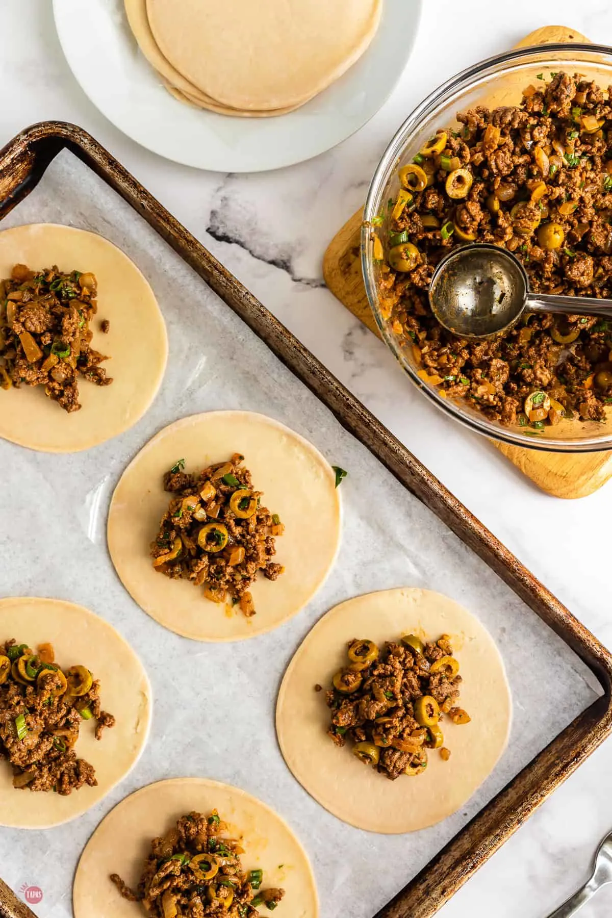 open empanadas on baking sheet