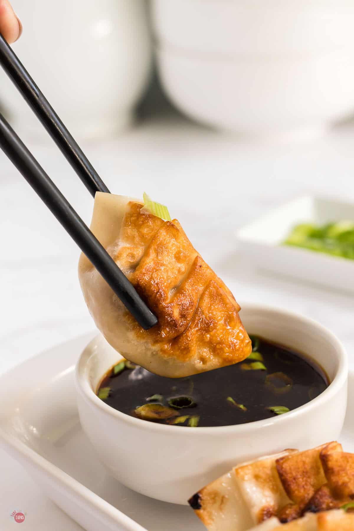 pan fried dumpling in chopsticks