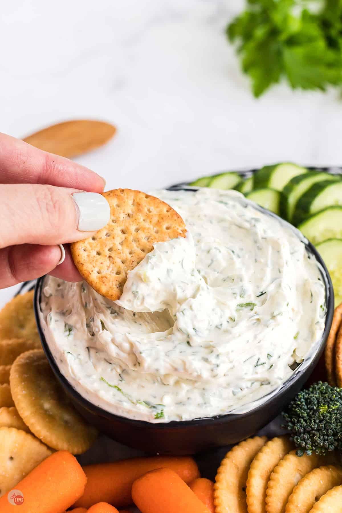 cracker in a bowl of cream cheese dip