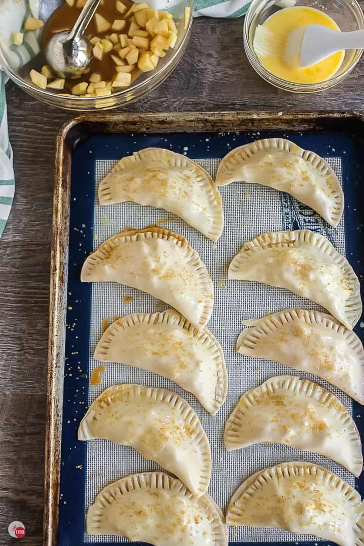 unbaked empanadas with egg wash on a baking sheet