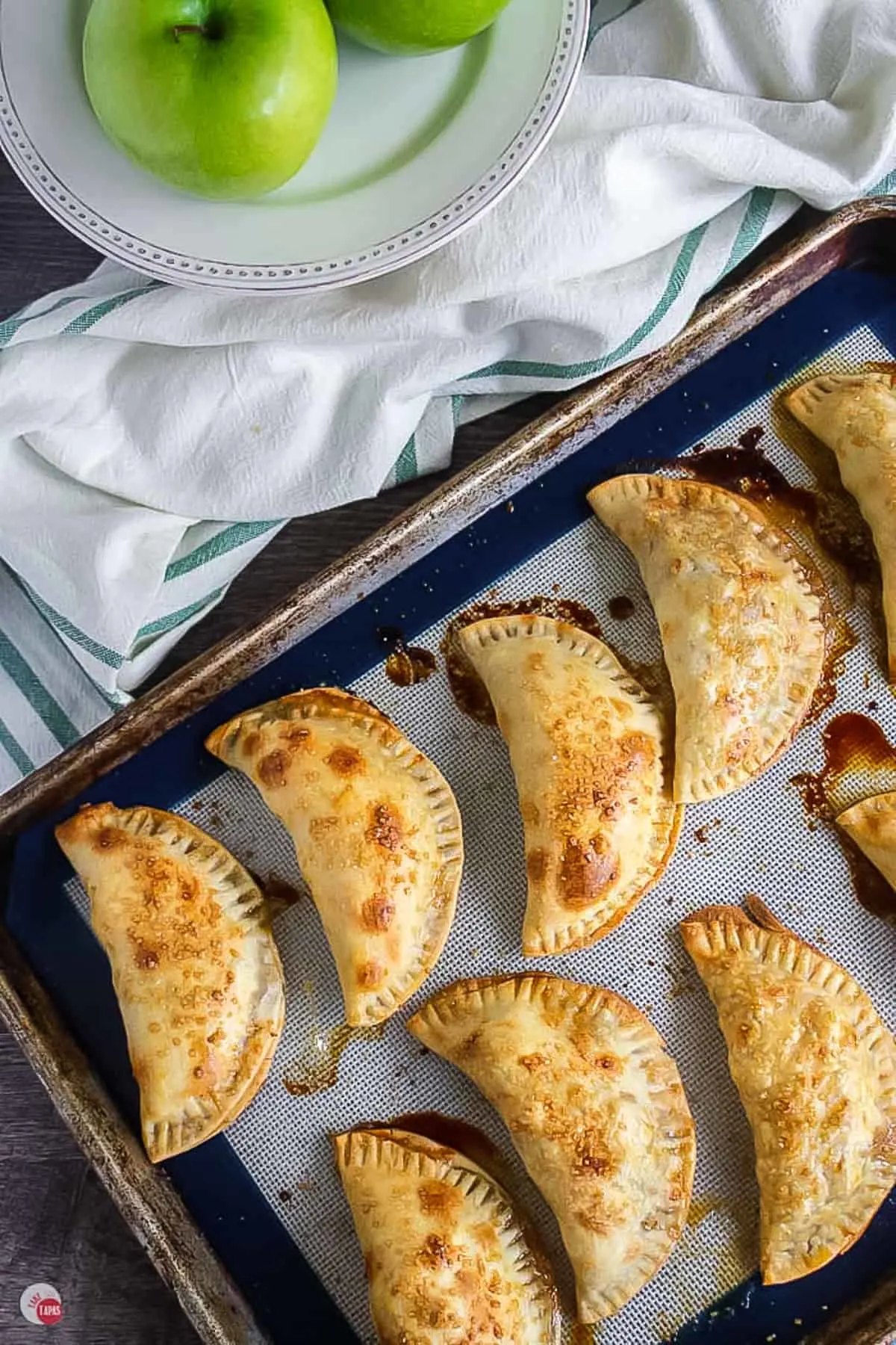baked caramel apple empanadas on a baking sheet