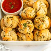 overhead picture of bowl of garlic knots with sauce