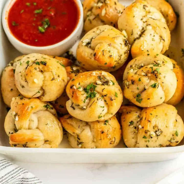 overhead picture of bowl of garlic knots with sauce