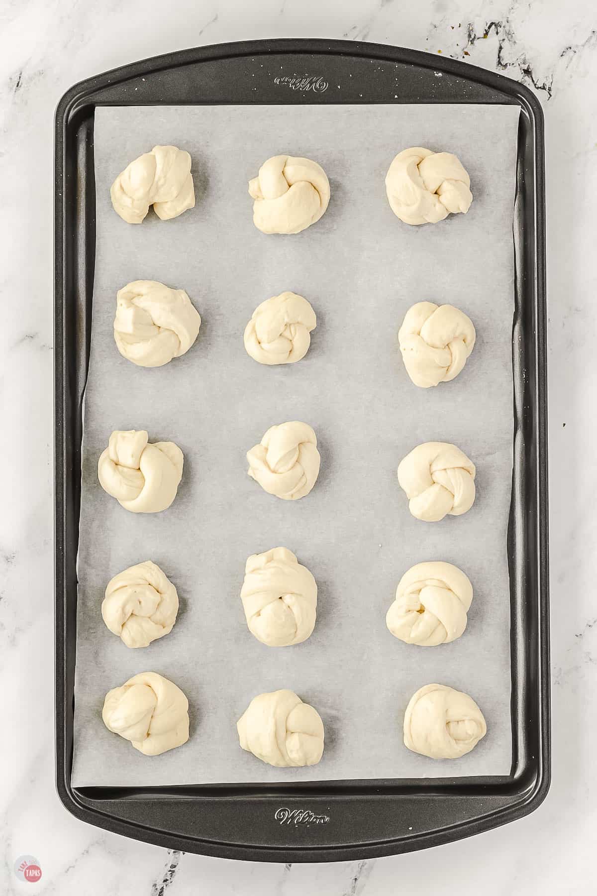 unbaked garlic knots on a baking sheet