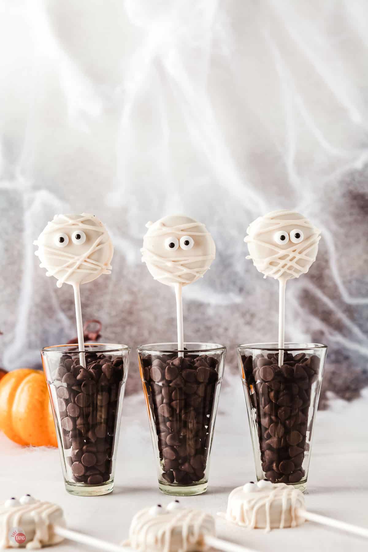three glasses with lollipops