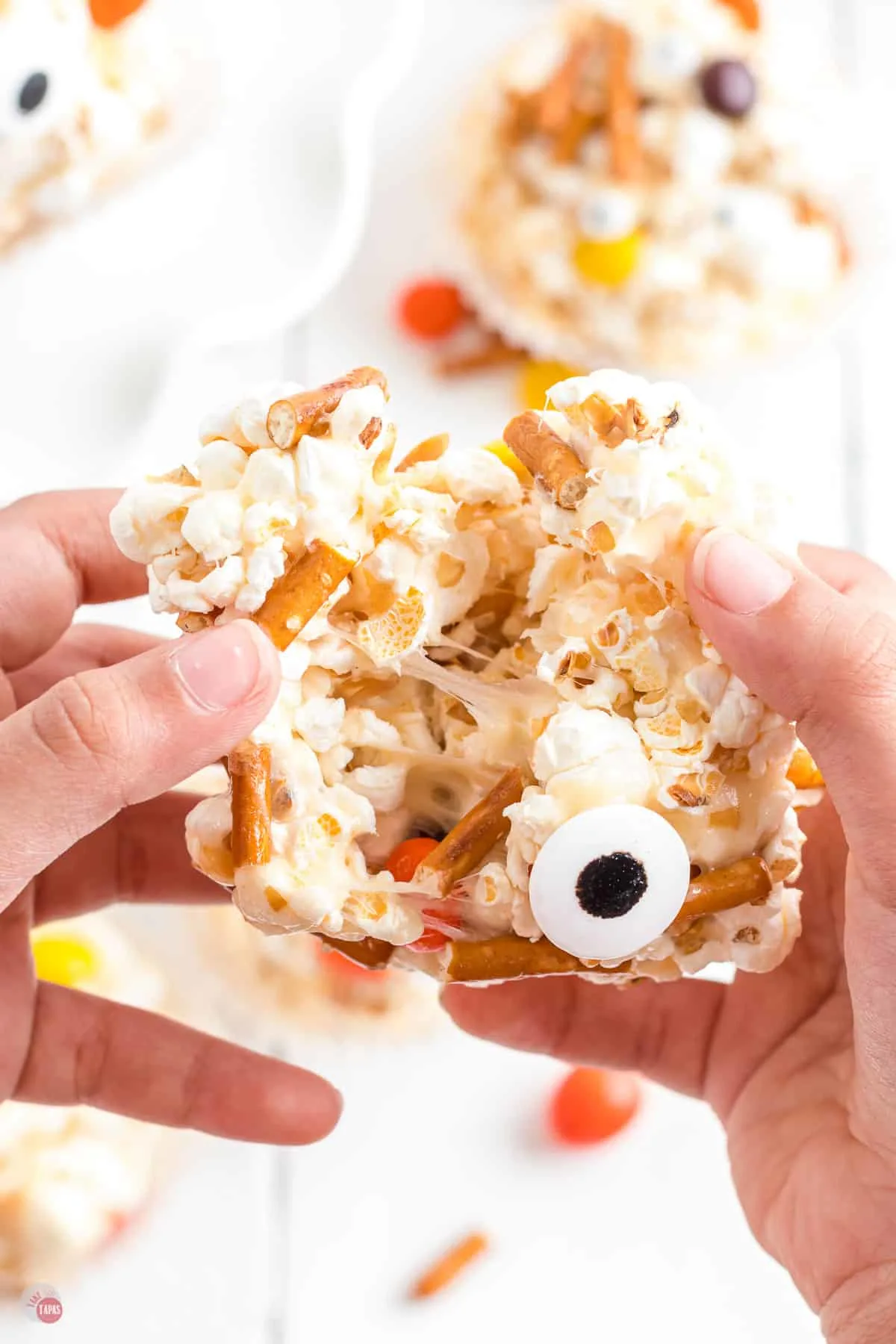 two hands pulling apart a popcorn ball