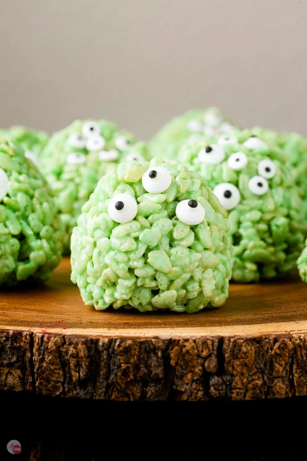 wood tray with green rice krispie treats with eyes