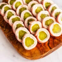 wood platter of pickle roll ups