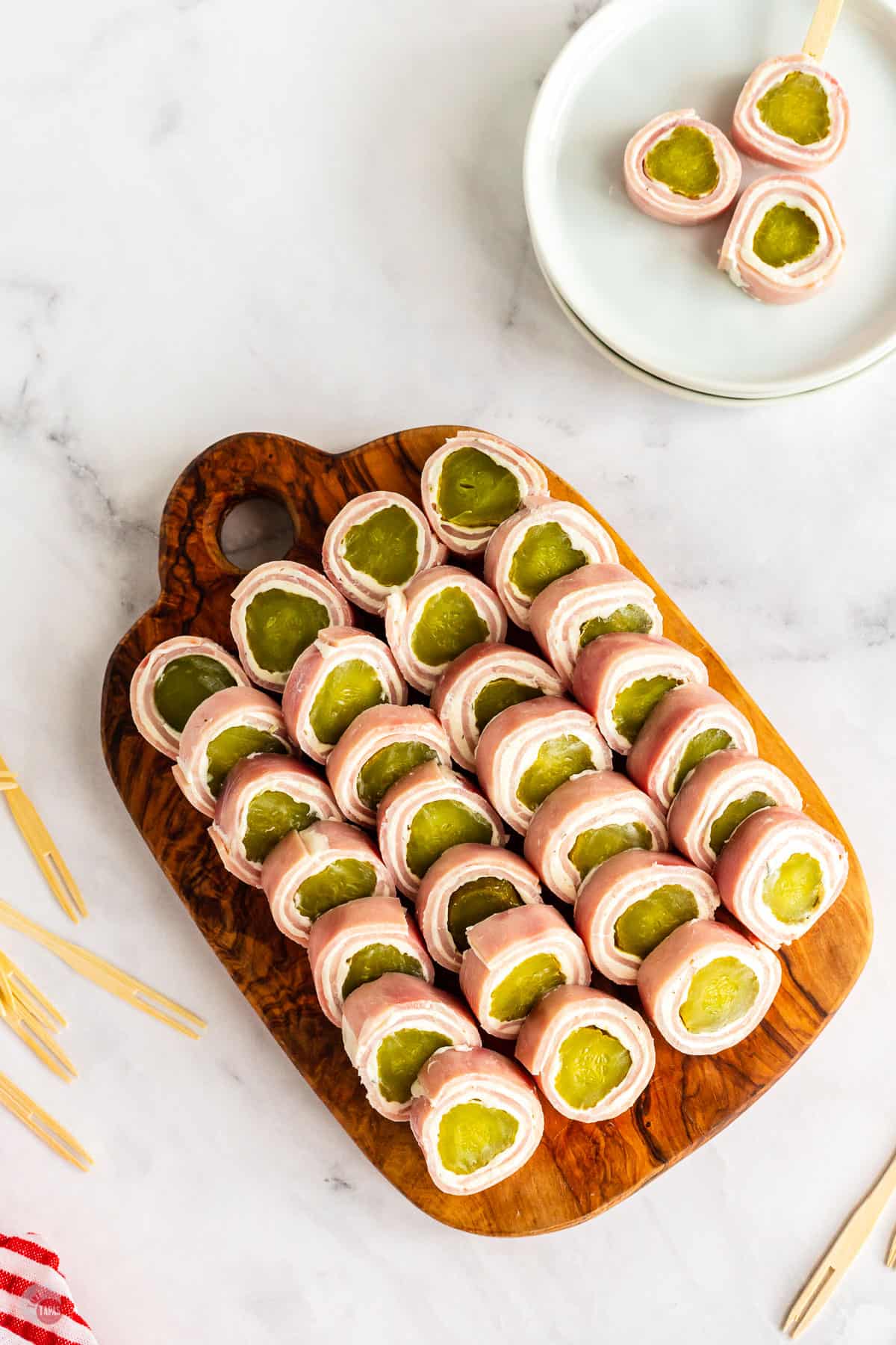 overhead picture of pickle roll ups on a wood board