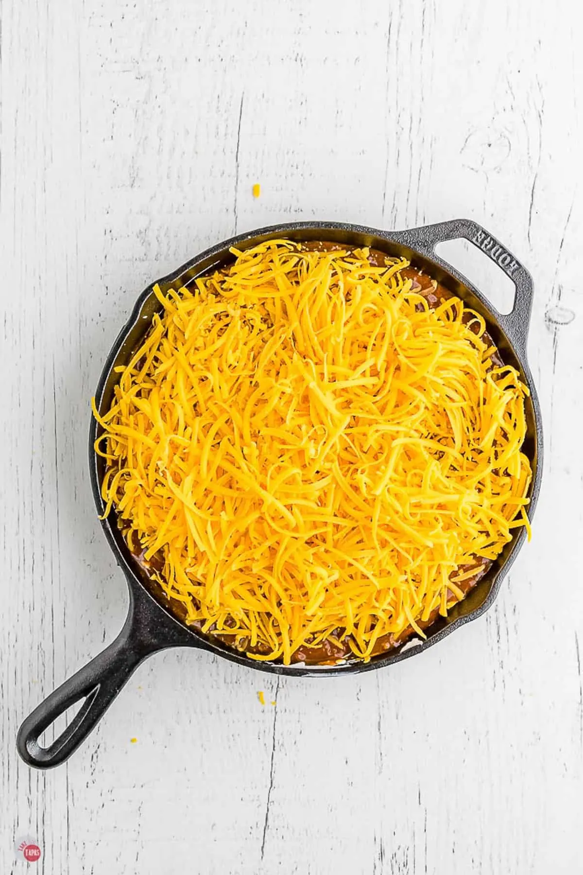 cast iron skillet with cheese on top