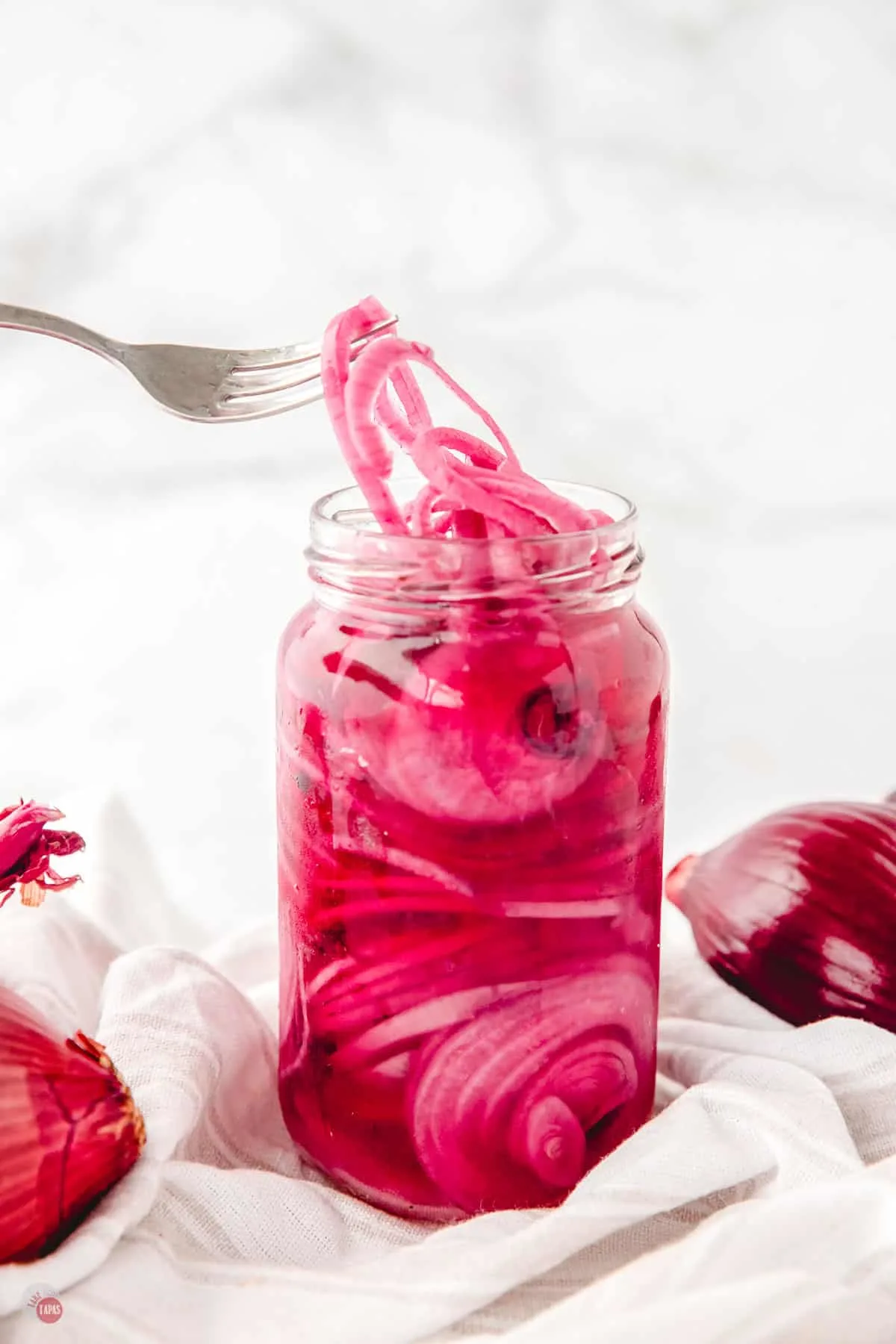 jar of pickled red onions and a fork