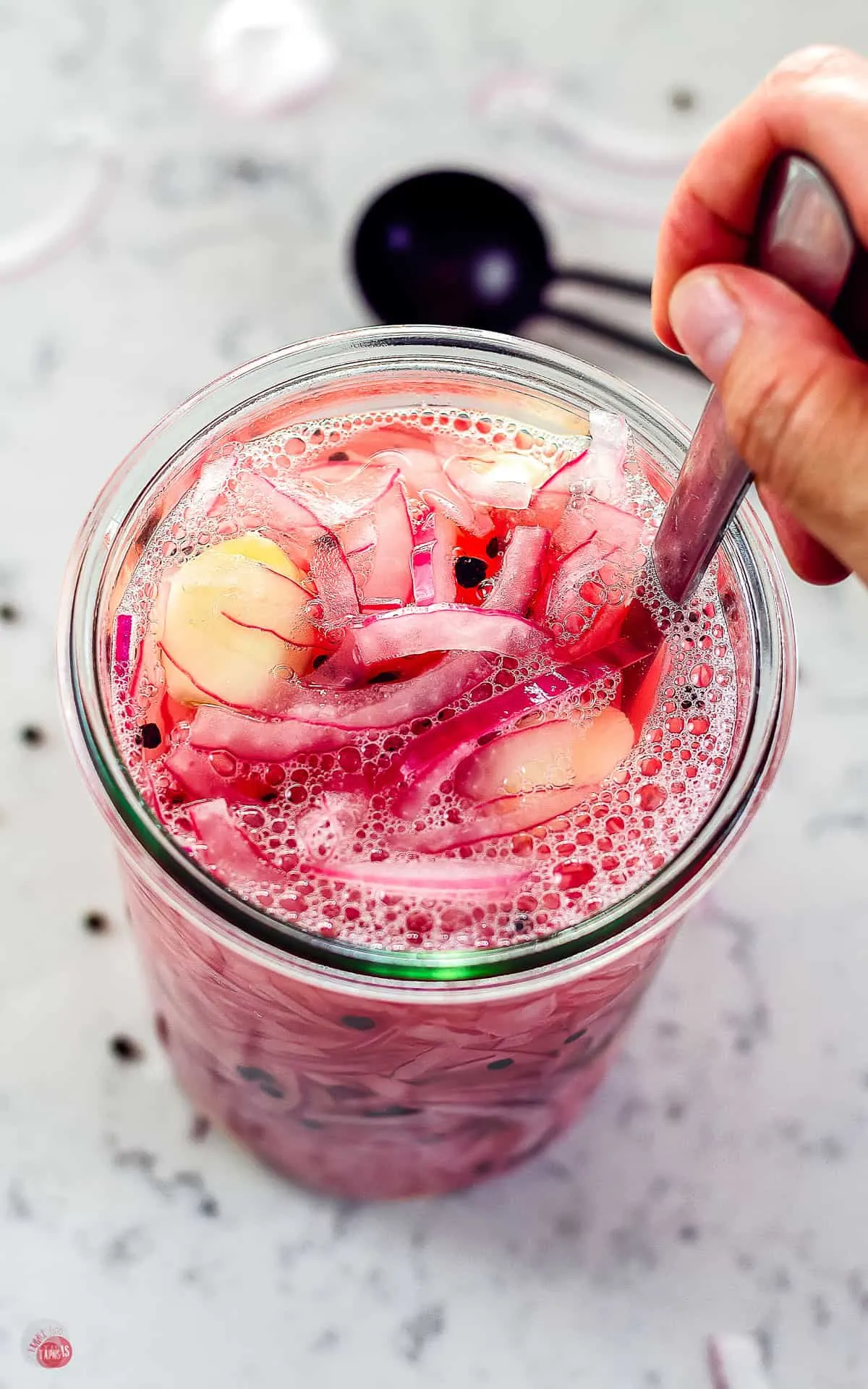 spoon and onions in a jar with garlic