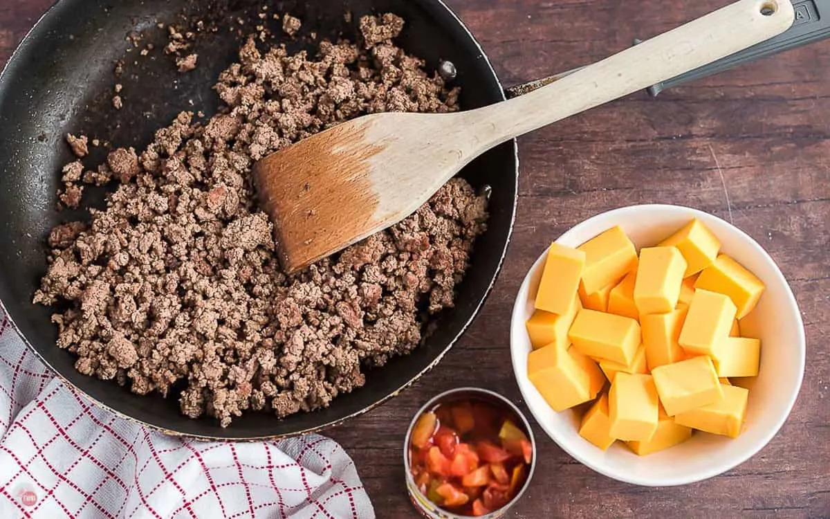 labeled picture of rotel dip ingredients in a pan with a spatula