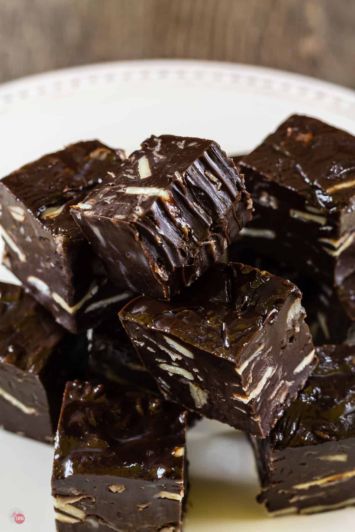 pile of small pieces of dark chocolate fudge on a white plate
