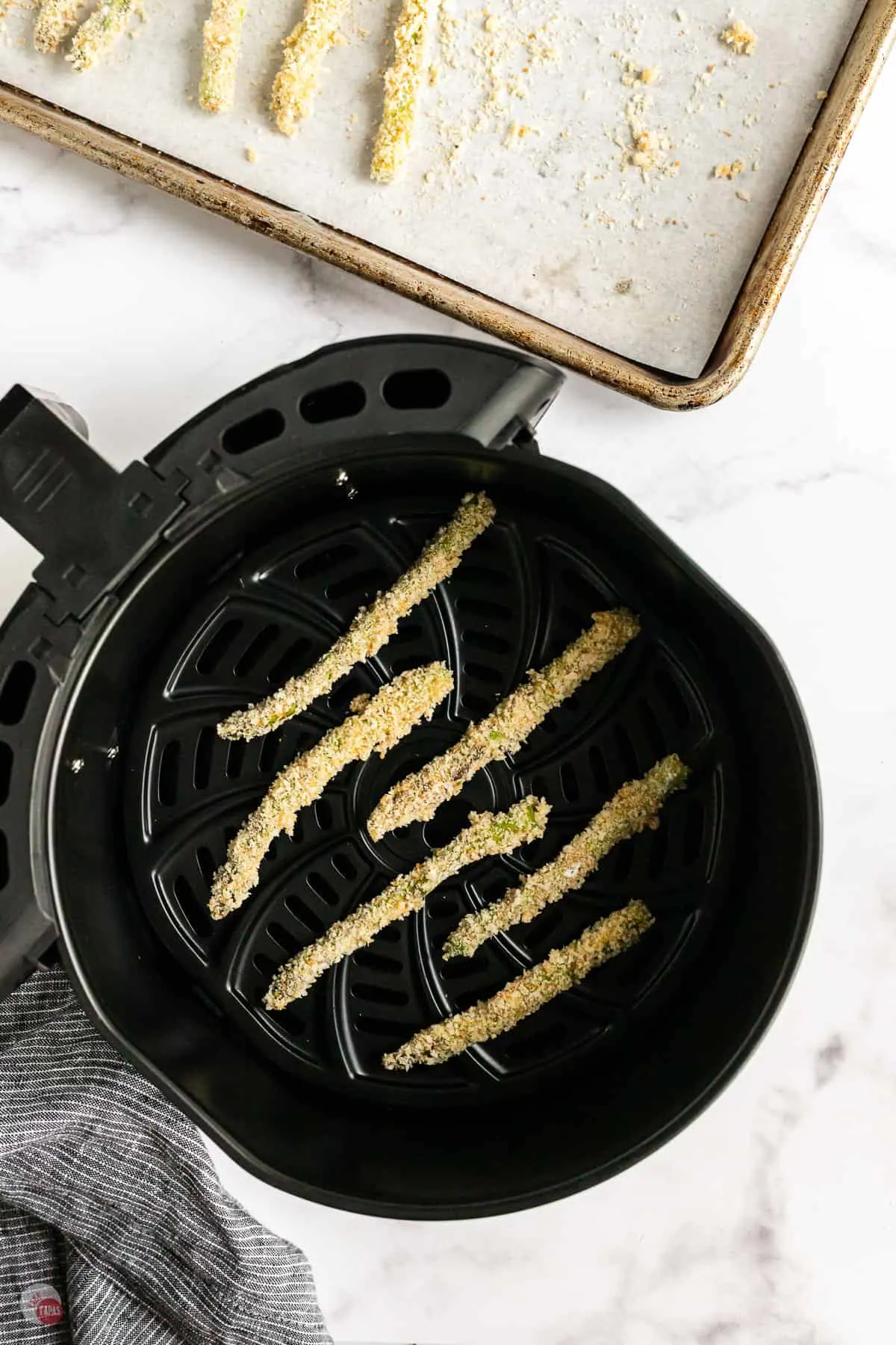 unbaked asparagus in an air fryer basket