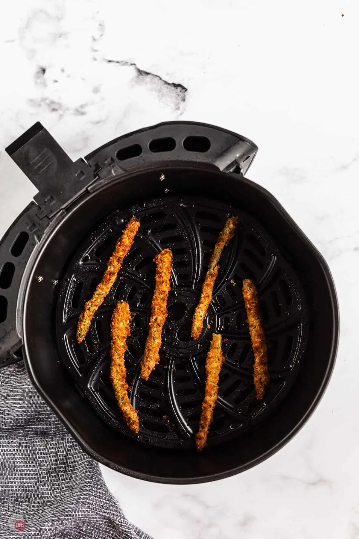 crispy asparagus in an air fryer basket