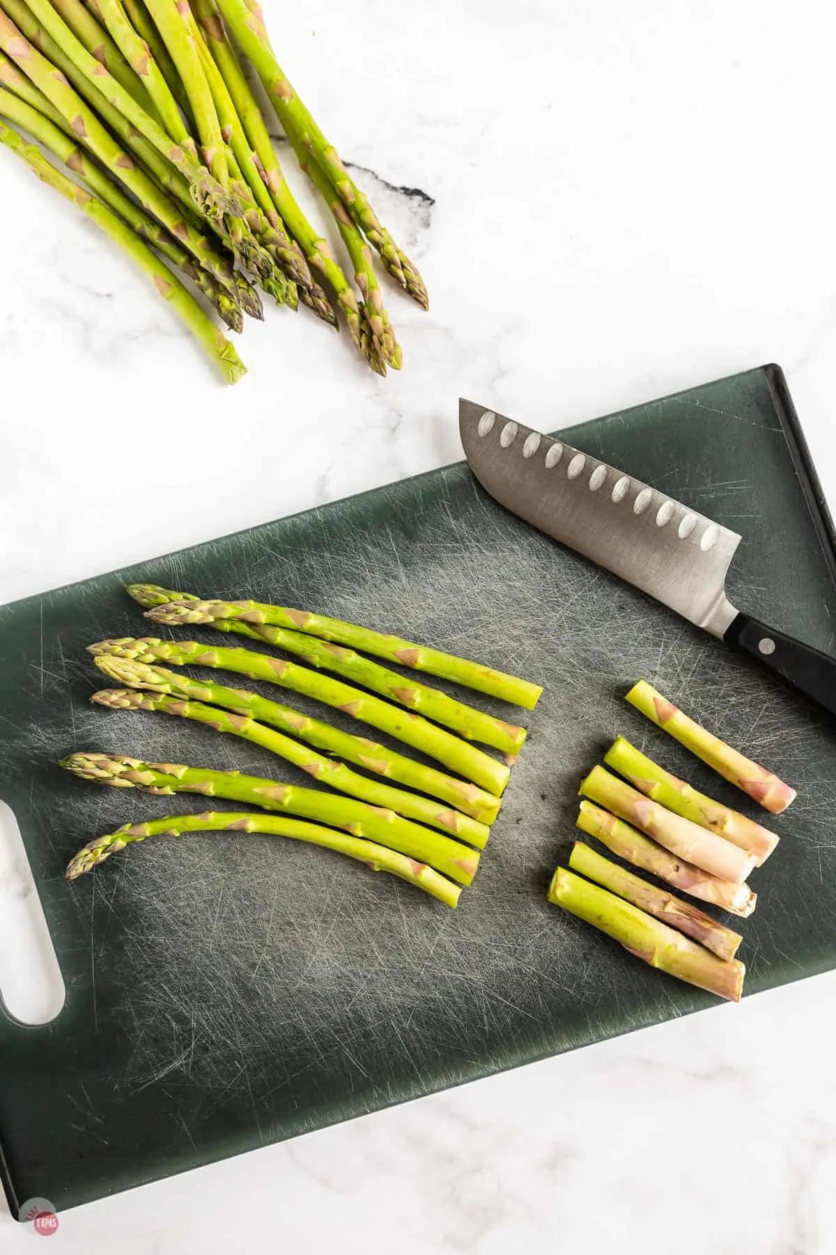 asparagus being cut on a board