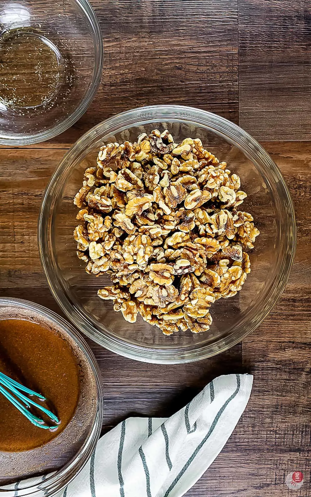 walnuts in a bowl next to a bowl of sugar mix