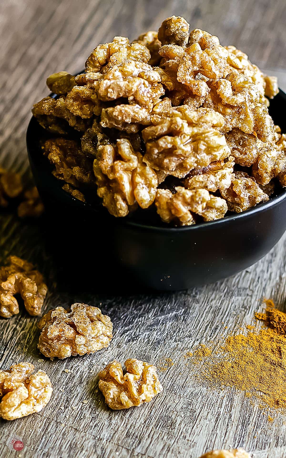 spiced walnuts in a black bowl