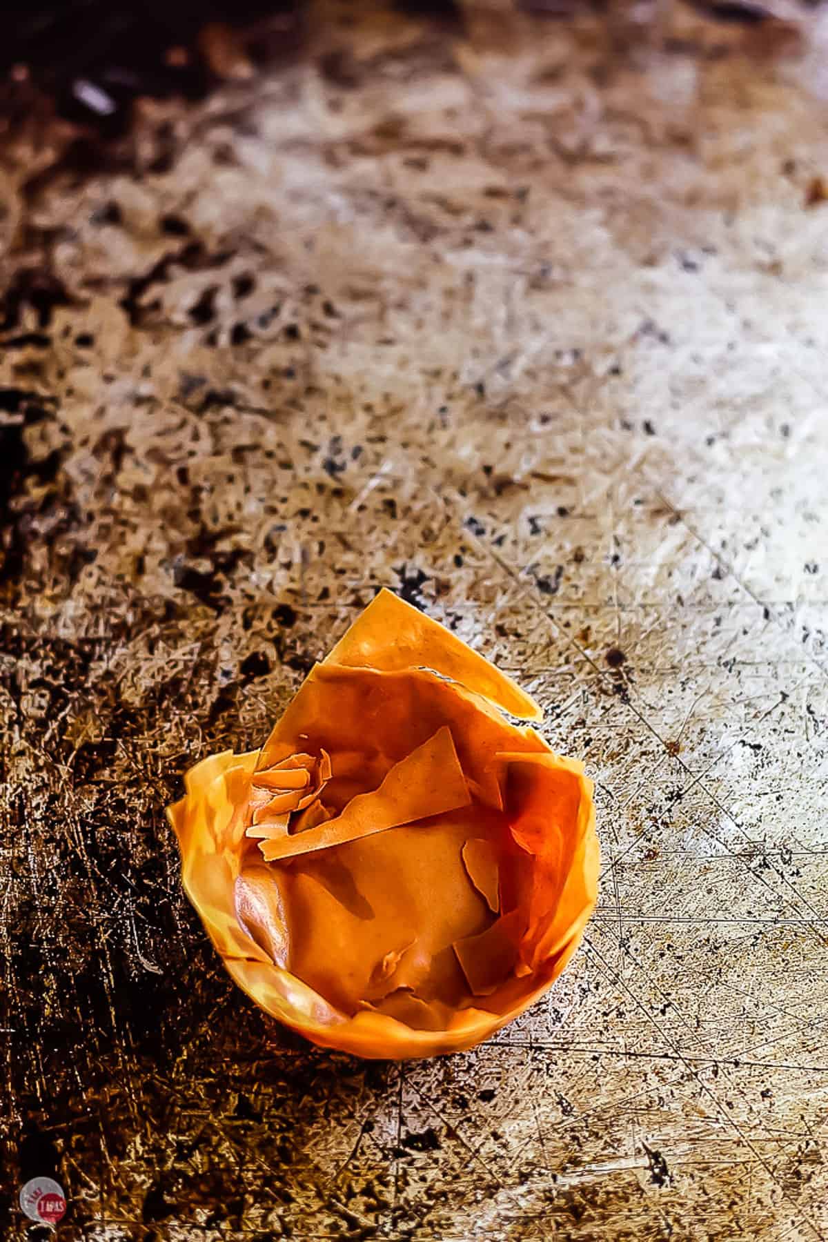 overcooked pastry cup on a baking sheet