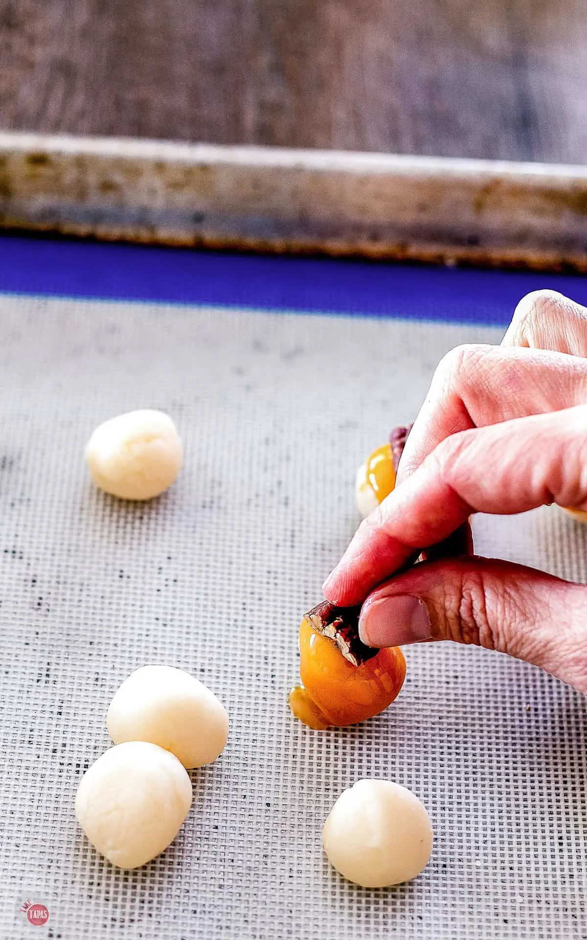 person putting pecan on truffle