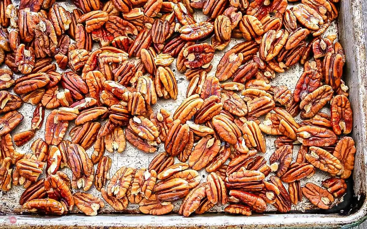 close up of toasted pecans on a baking sheet