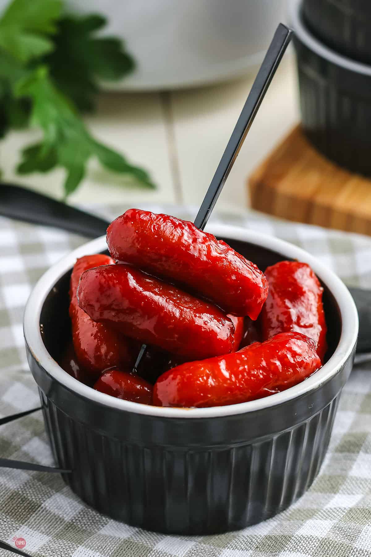 cocktail weenies in a black bowl with a toothpick