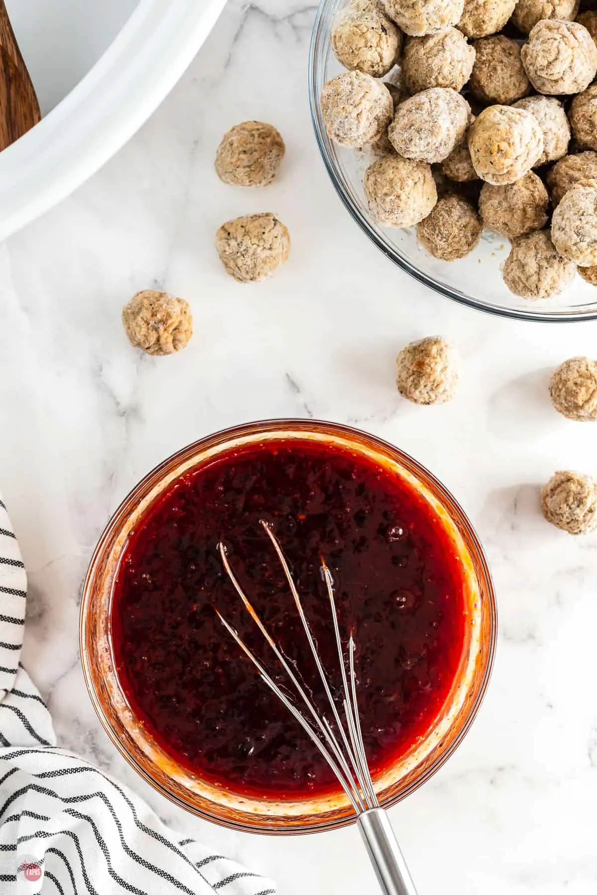 meatball sauce in a bowl with a whisk