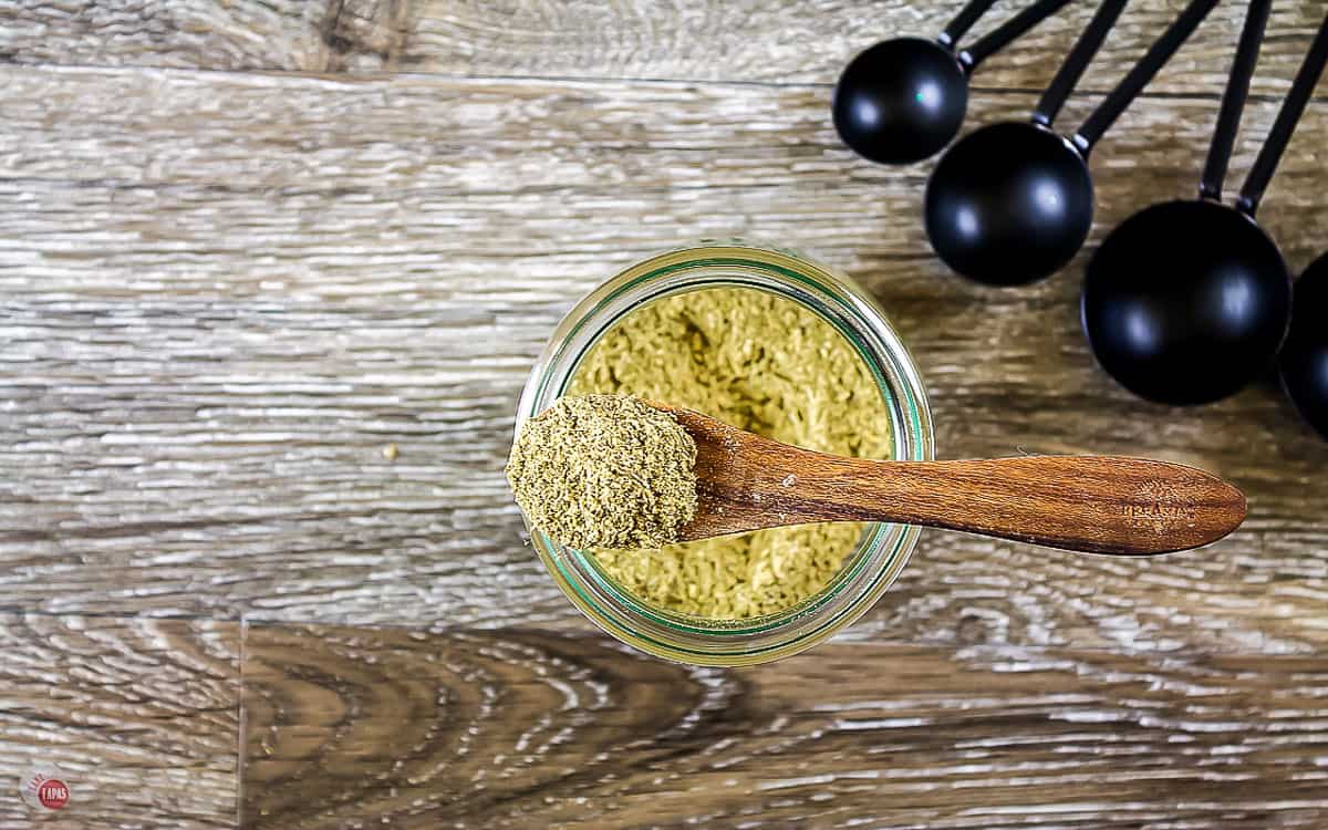 overhead picture of seasoning in a wood spoon on top of a jar