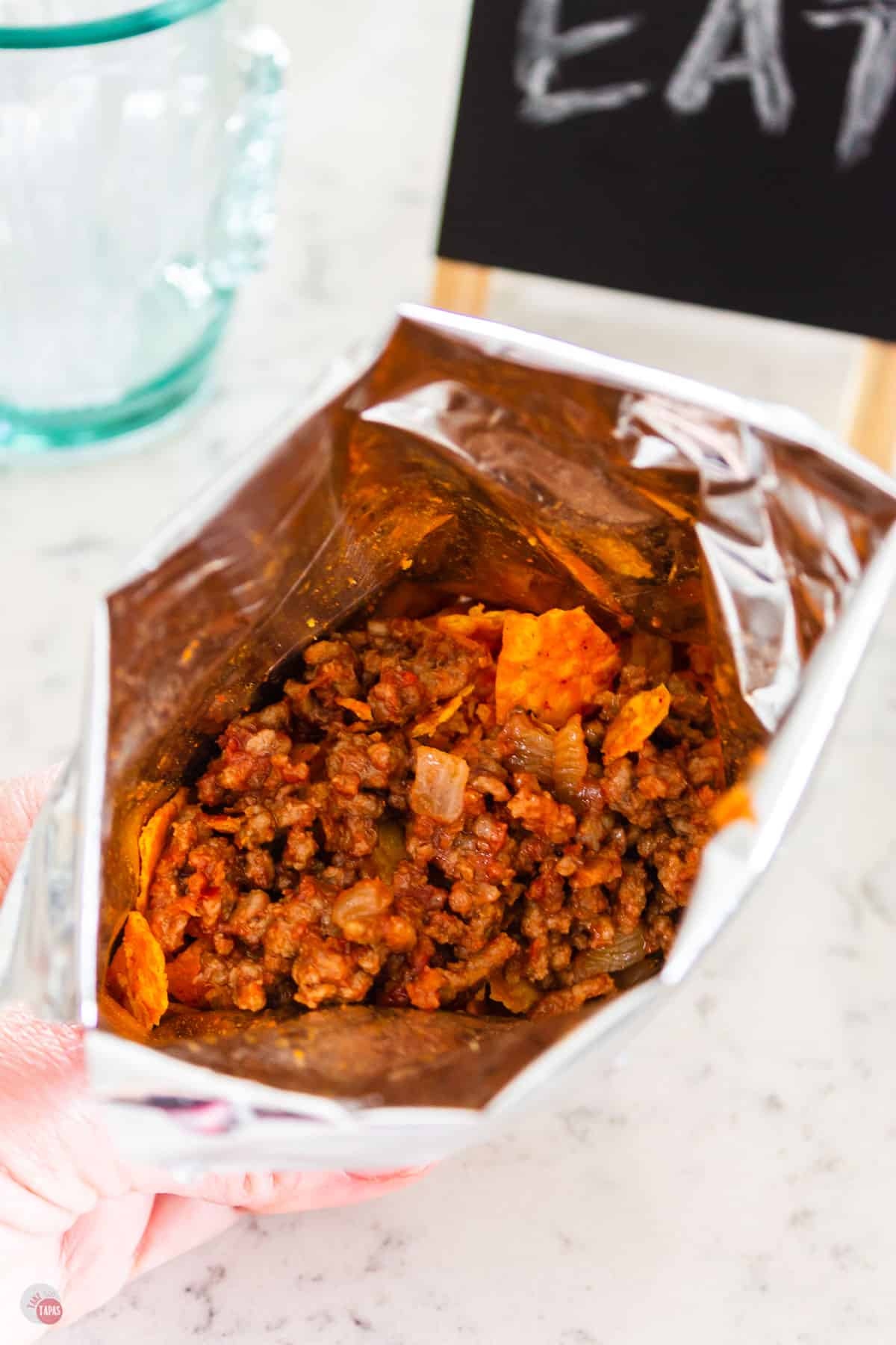 overhead shot of crumbled nachos with meat on top