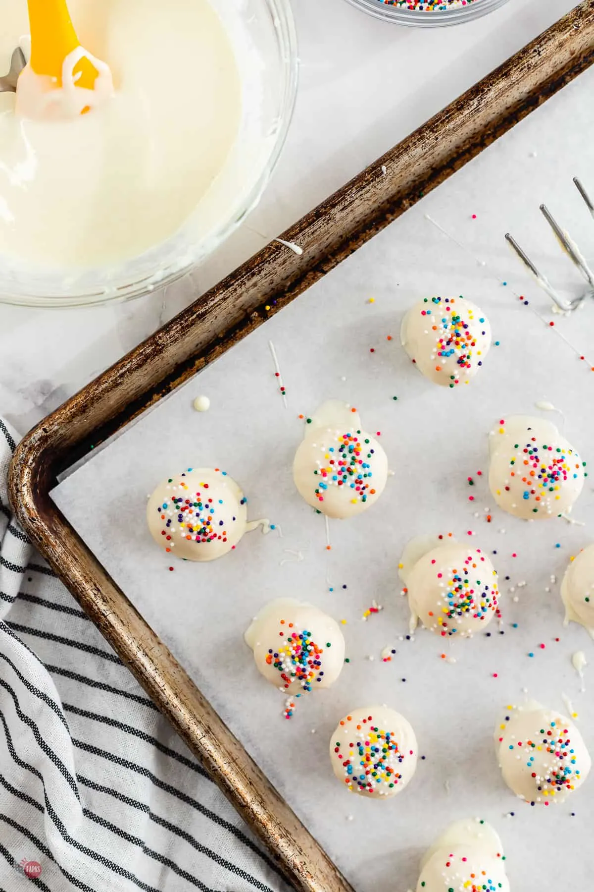 truffles dipped on a baking sheet with sprinkles