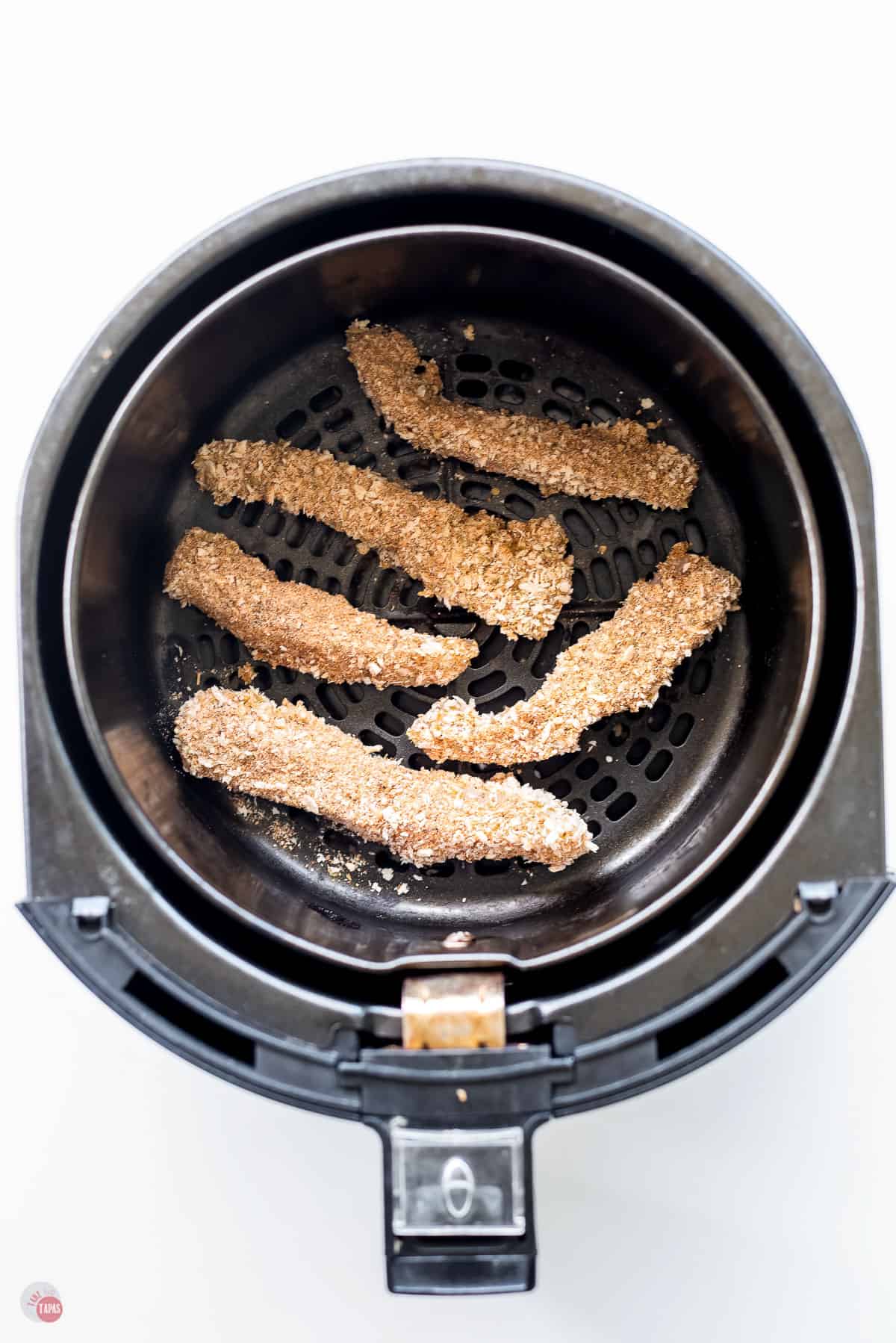 unbaked fish sticks in an air fryer basket