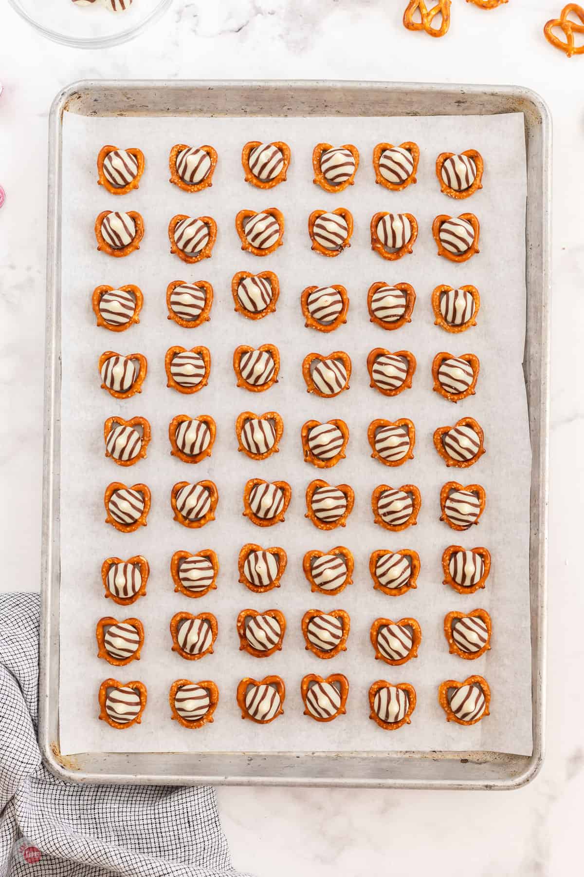 pretzel on a baking sheet topped with hugs