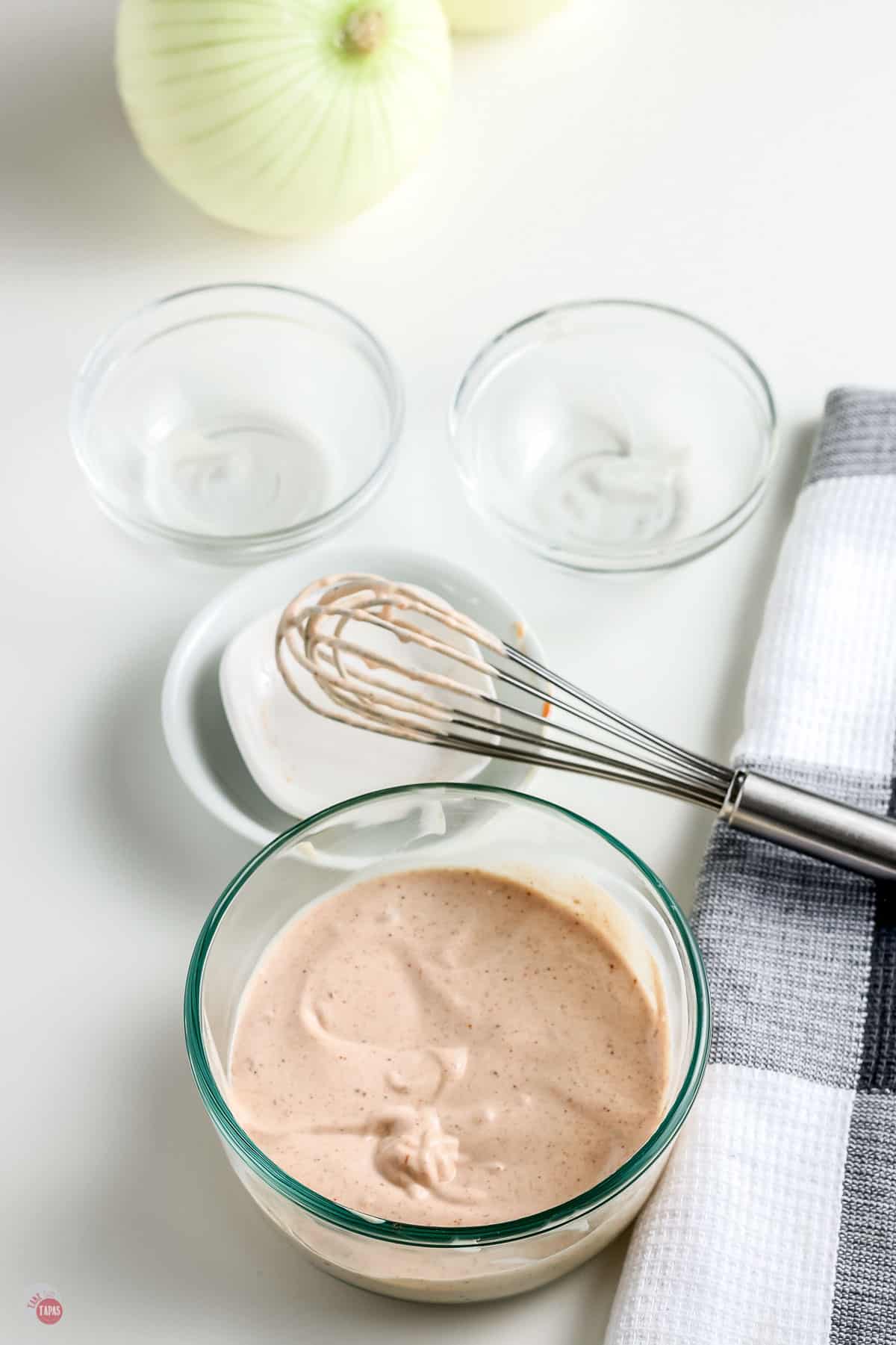 mixed dipping sauce in a clear bowl with a whisk