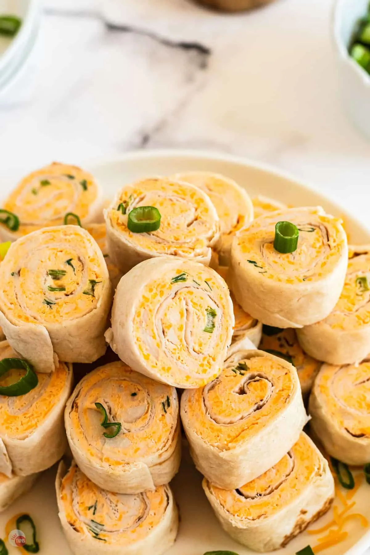 close up of buffalo chicken pinwheel sandwiches on a plate