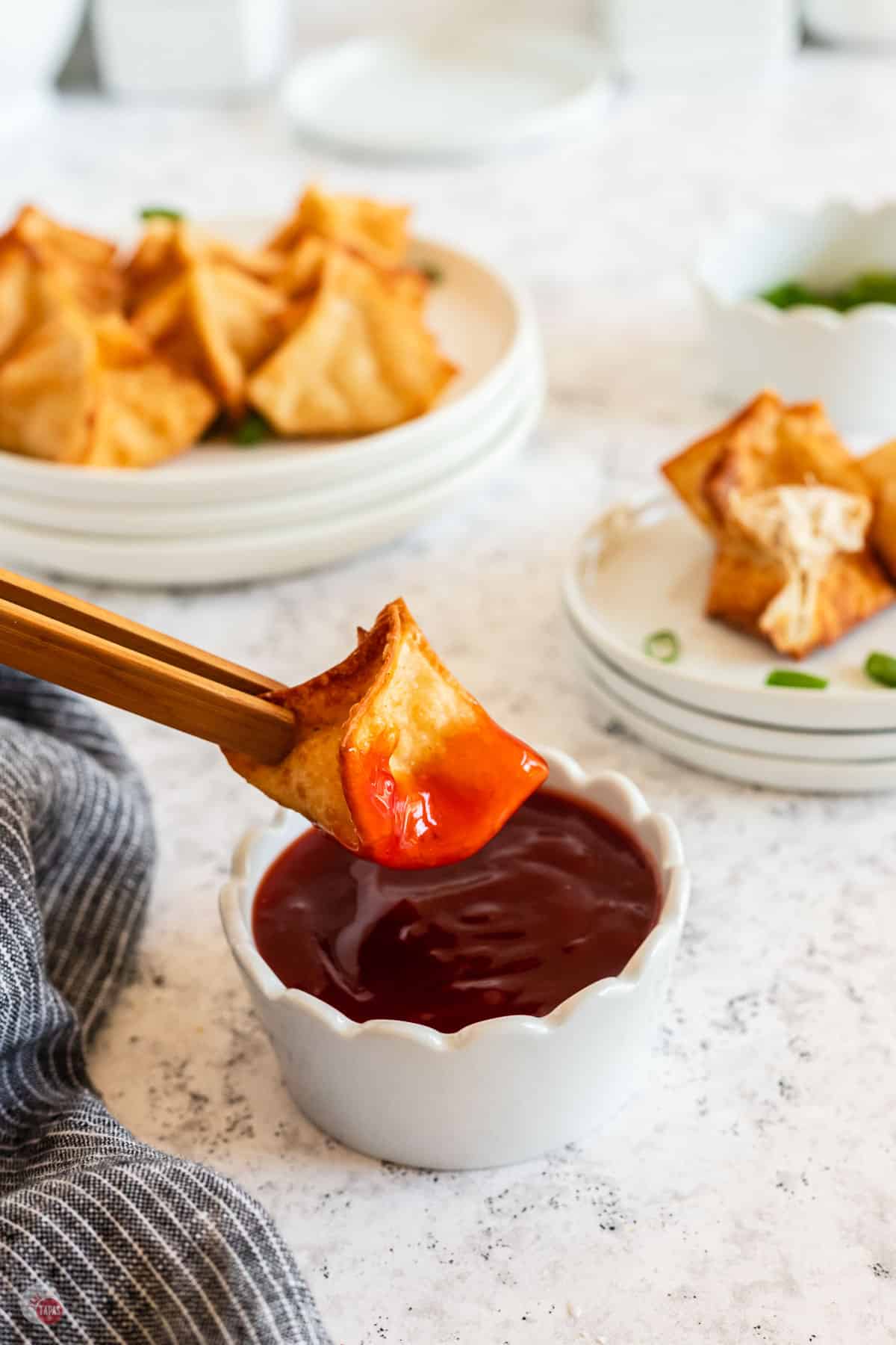 crab rangoon dipping in sweet and sour sauce