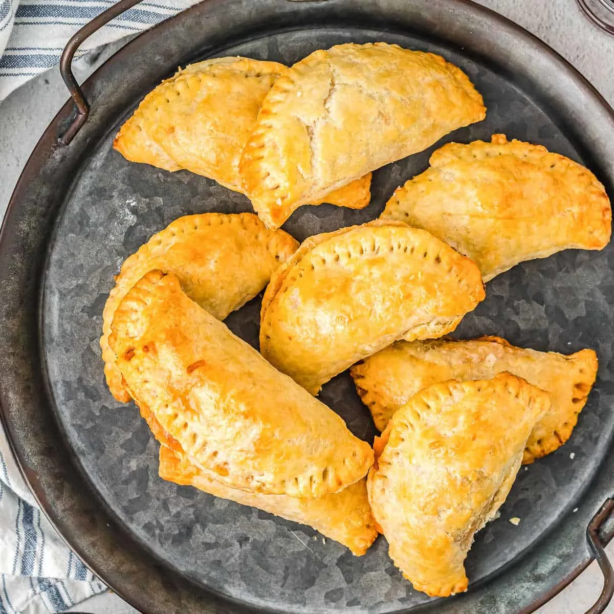 Round grey tray of empanadas.