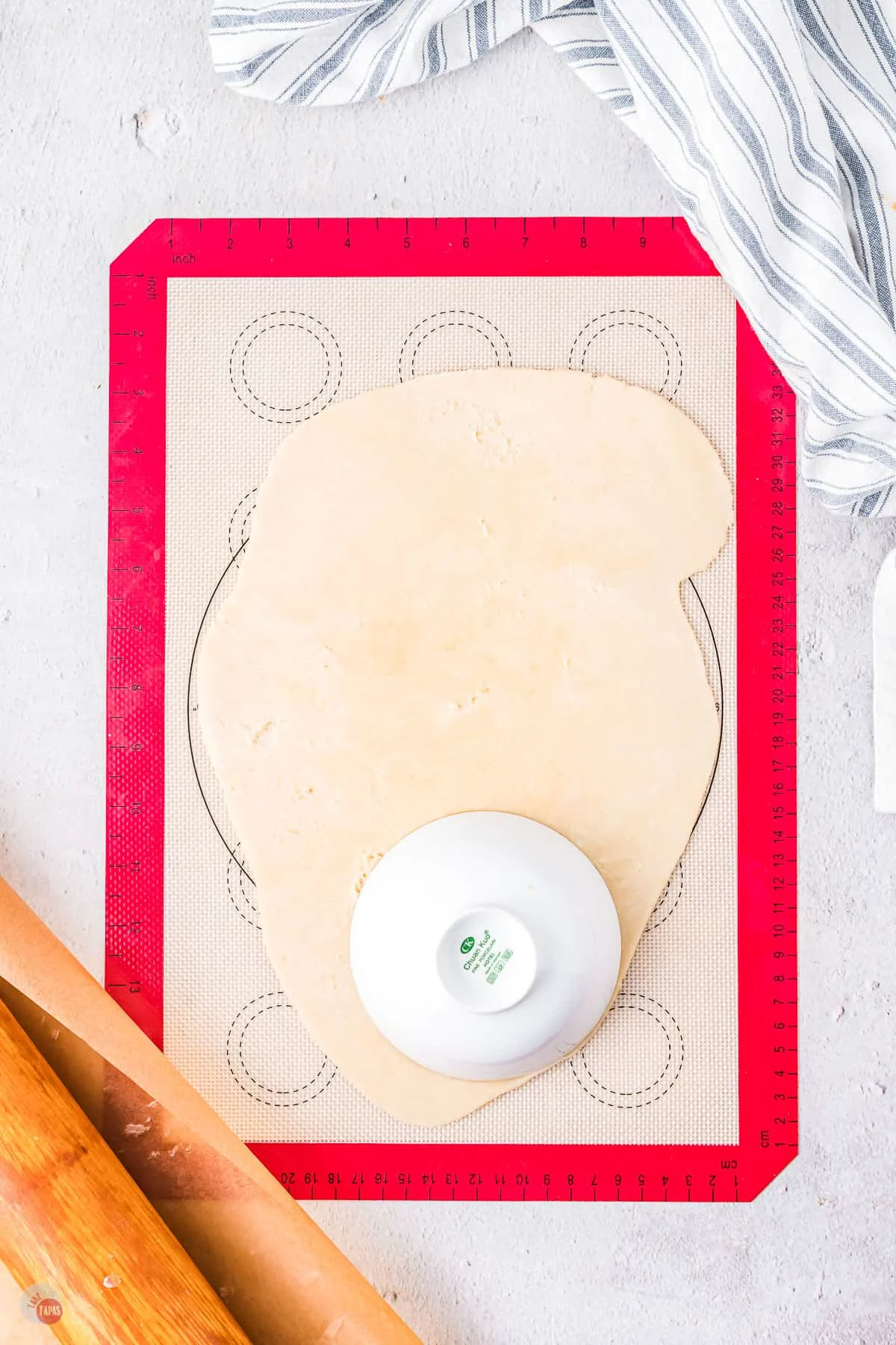 silicone baking sheet with dough on it and a rolling pin