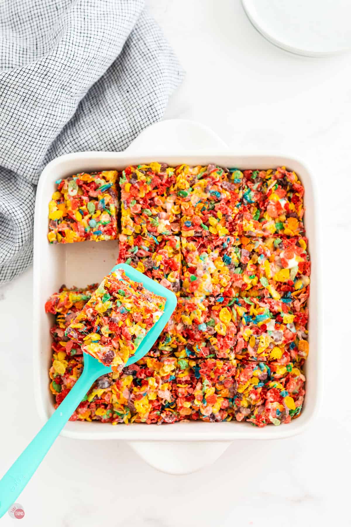 pan of fruity pebble treats cut with spatula