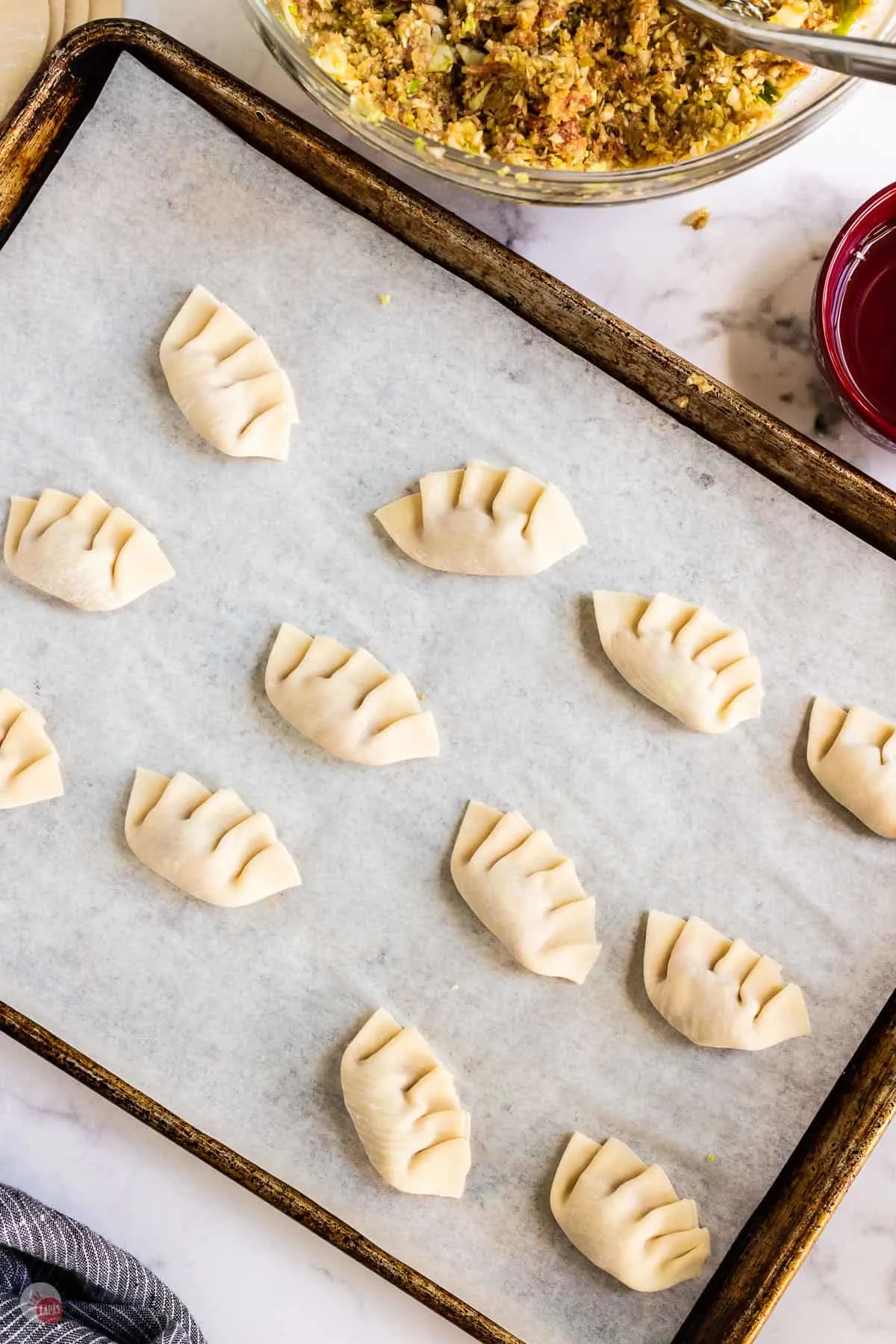 dumplings before frying on baking sheet